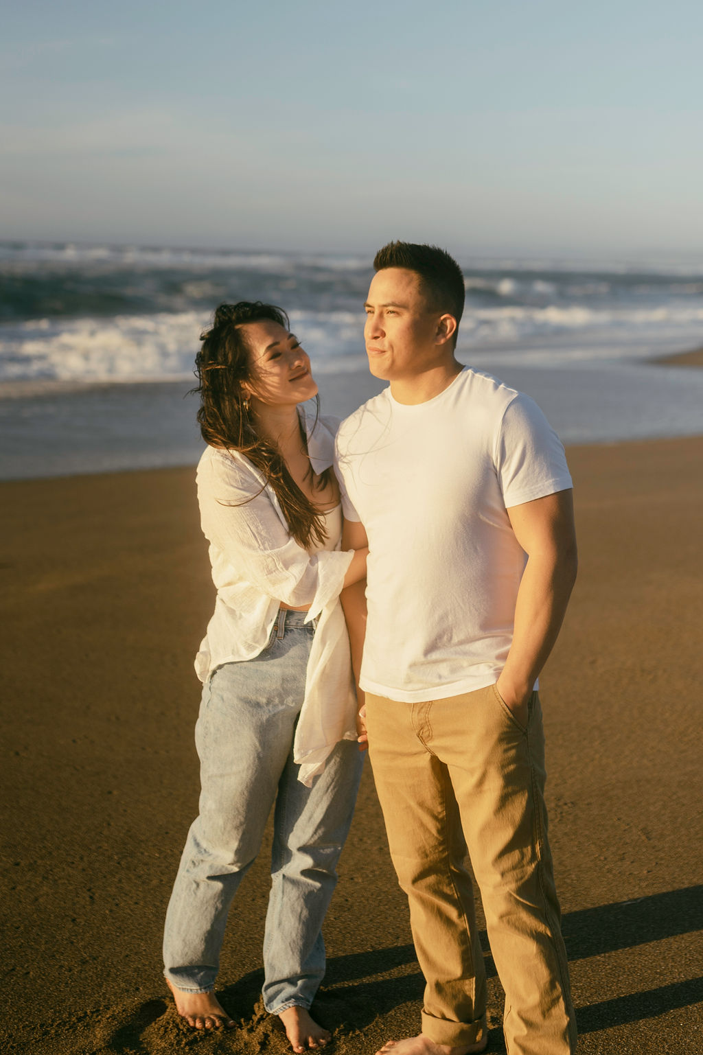 couple posing on the oceanside for their engagement pictures