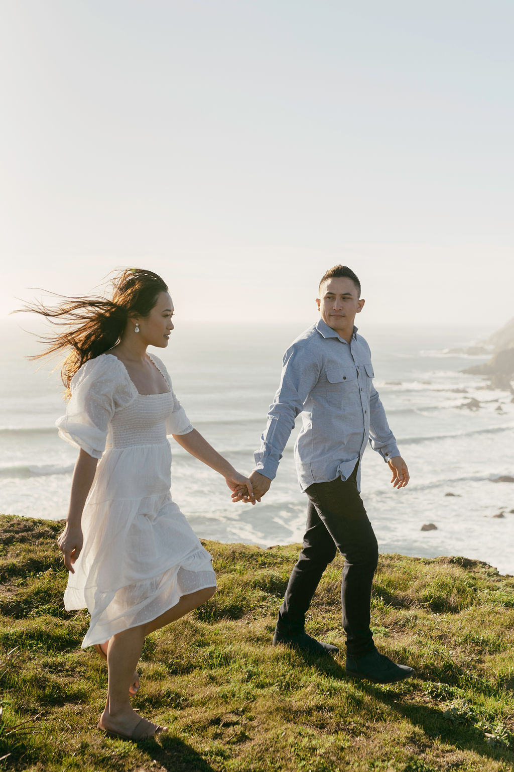 couple posing on the oceanside for their engagement pictures
