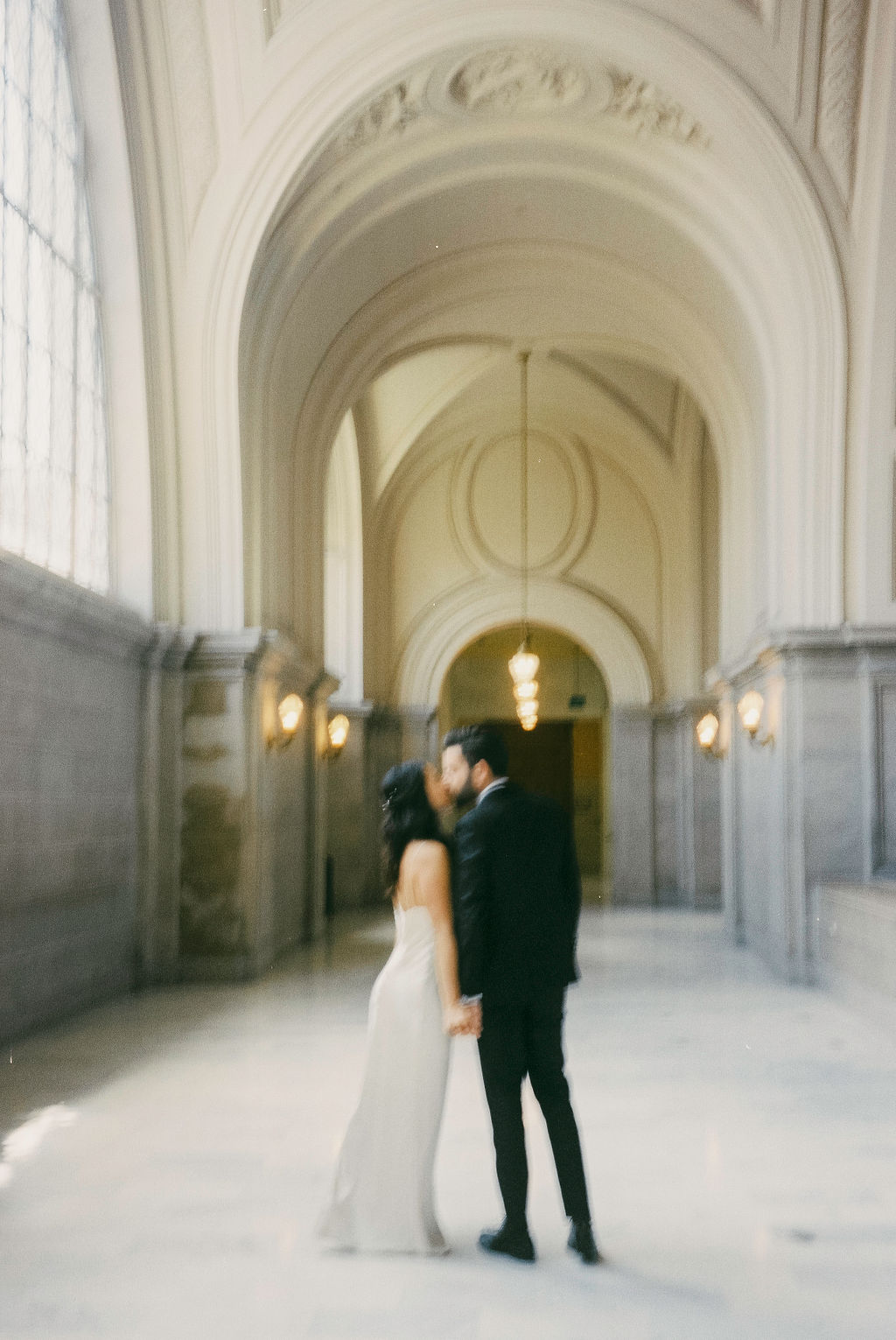 bride and groom posing at sf city hall for their elopement