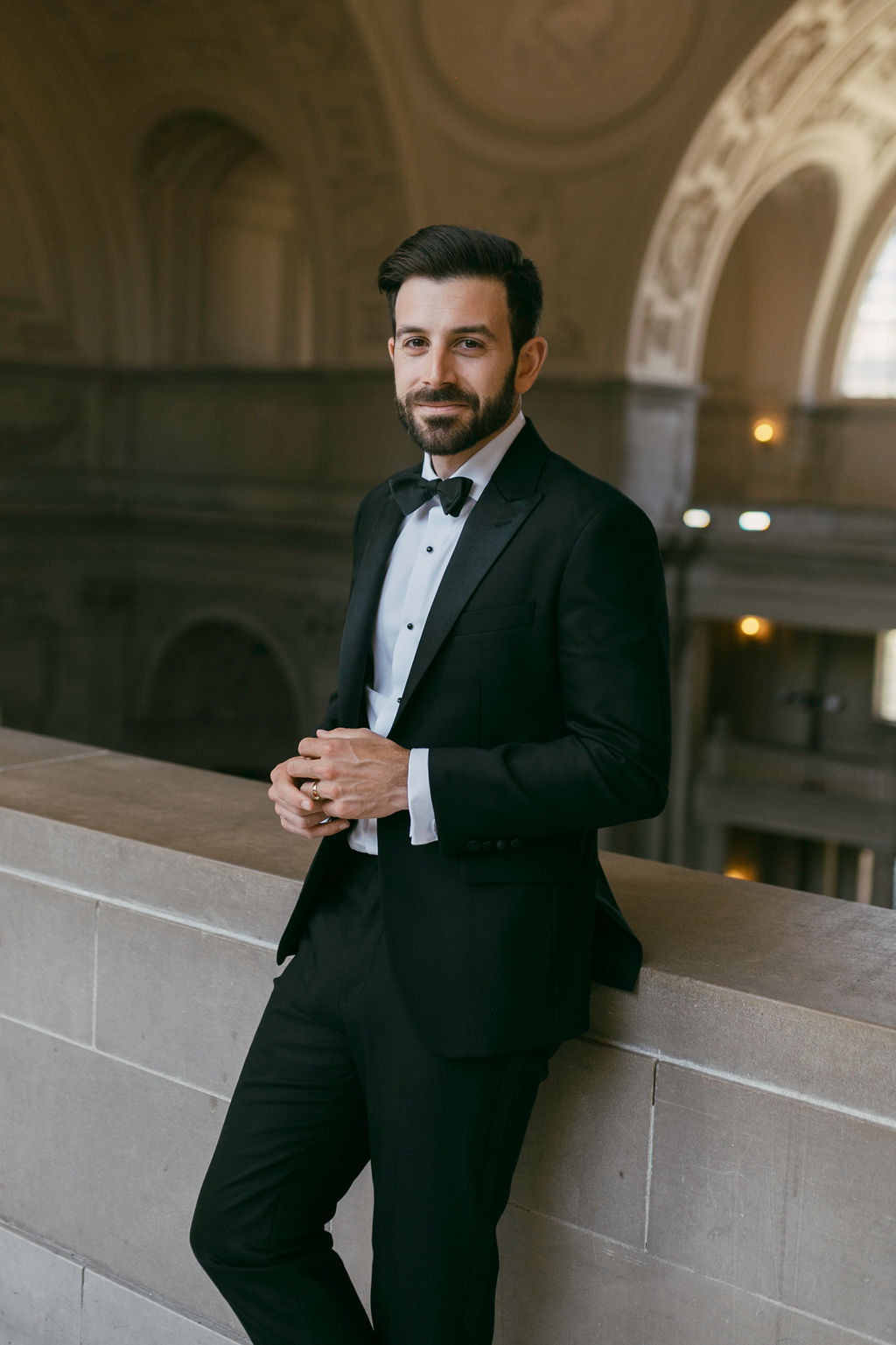 groom posing in a city hall for his wedding photos