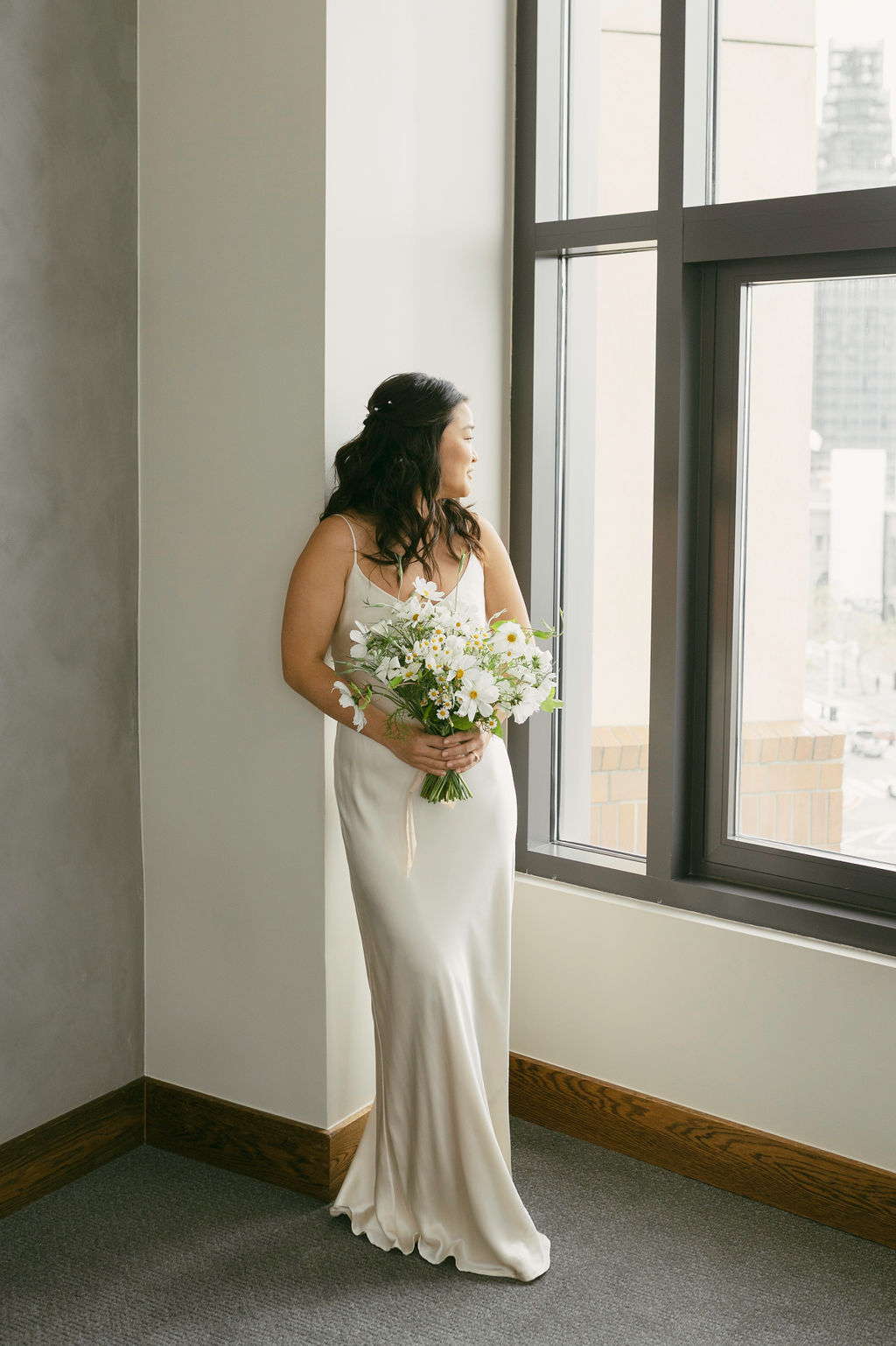 bride posing in front of a  window for her bridal portraits