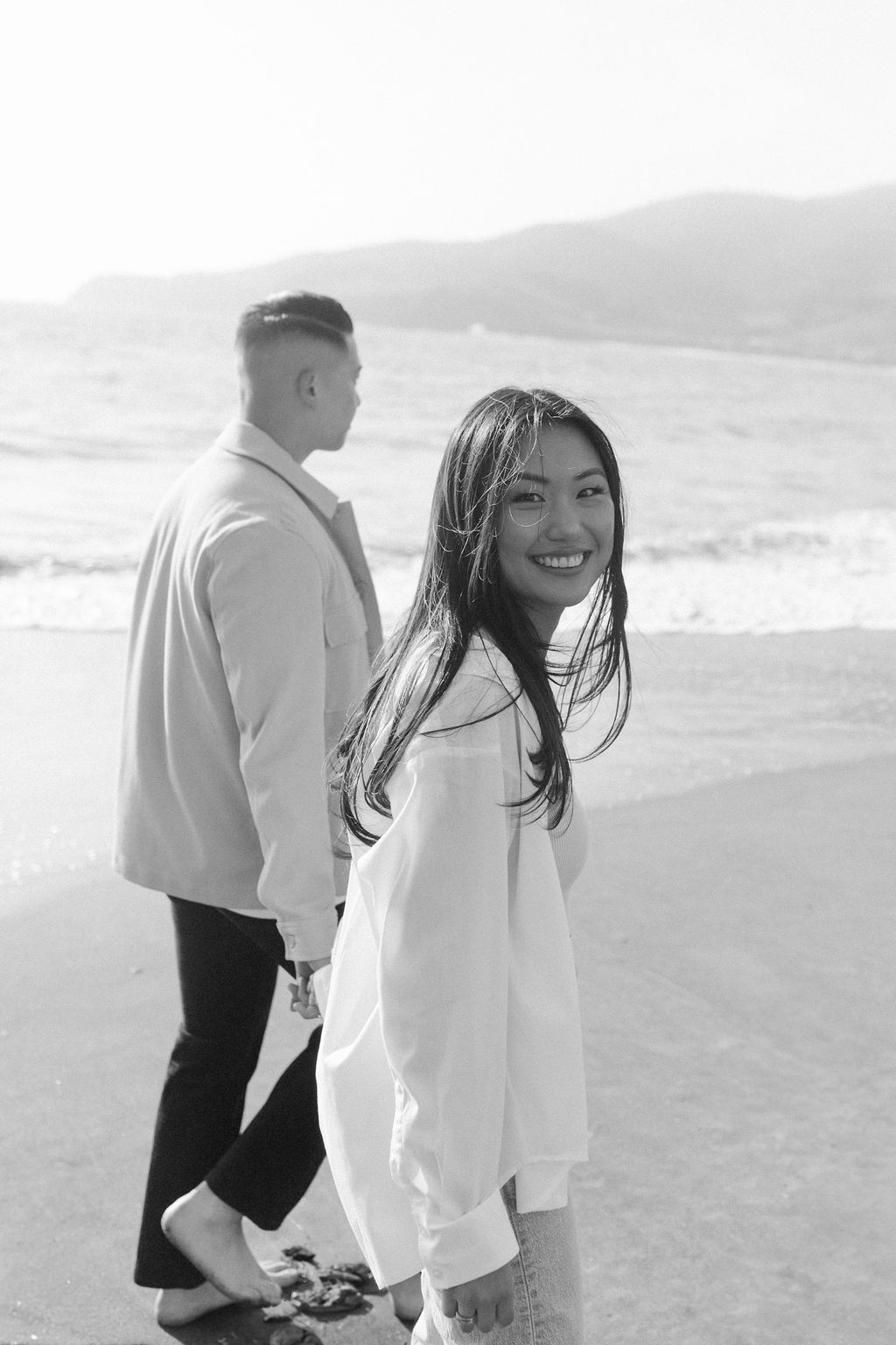 engagement pictures being taken in san francisco on the beach