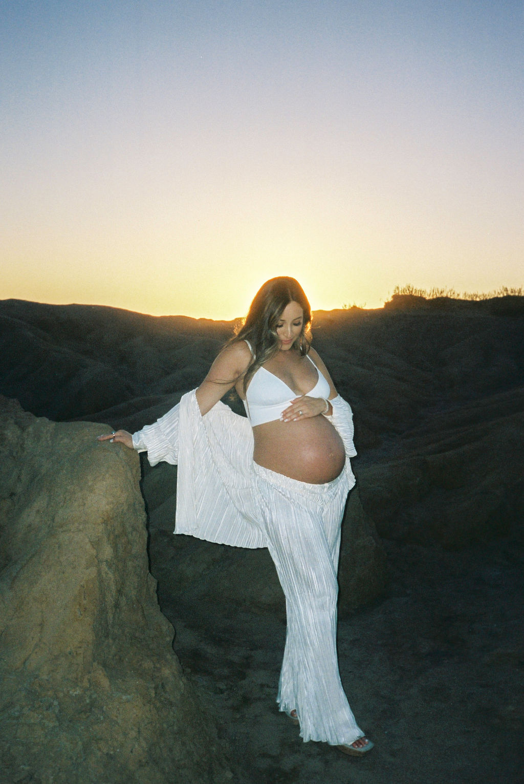 future mother posing on a beach in california for a maternity photoshoot