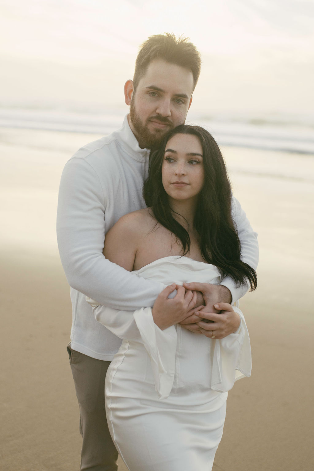 couple posing on a beach in california for their engagement photos